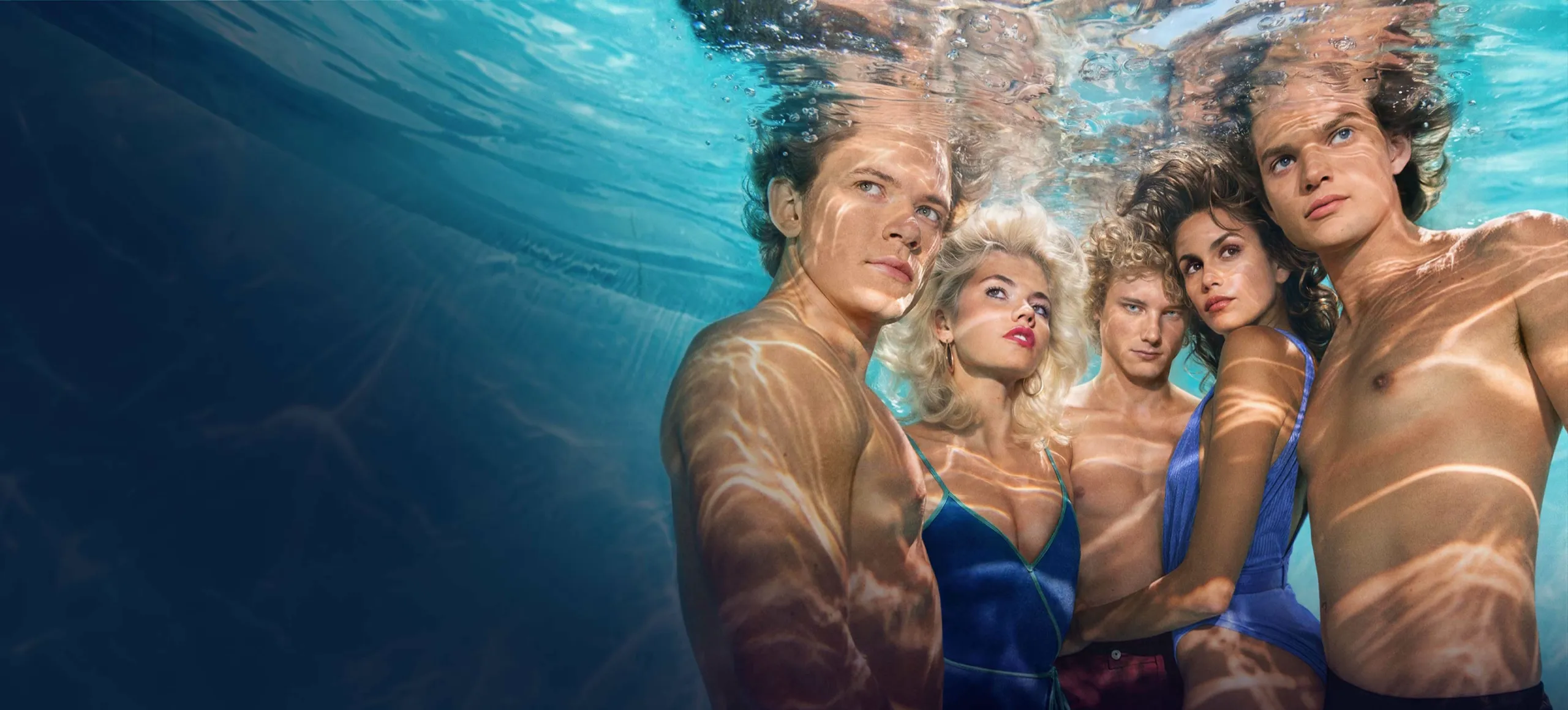 Key art for The Shards, featuring a group of young adults underwater, illuminated by shimmering sunlight and surrounded by deep blue water.