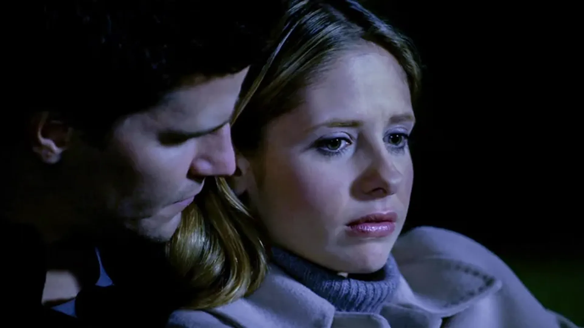 Buffy (Sarah Michelle Gellar) looks worried, with Angel (David Boreanaz) appearing close behind her.