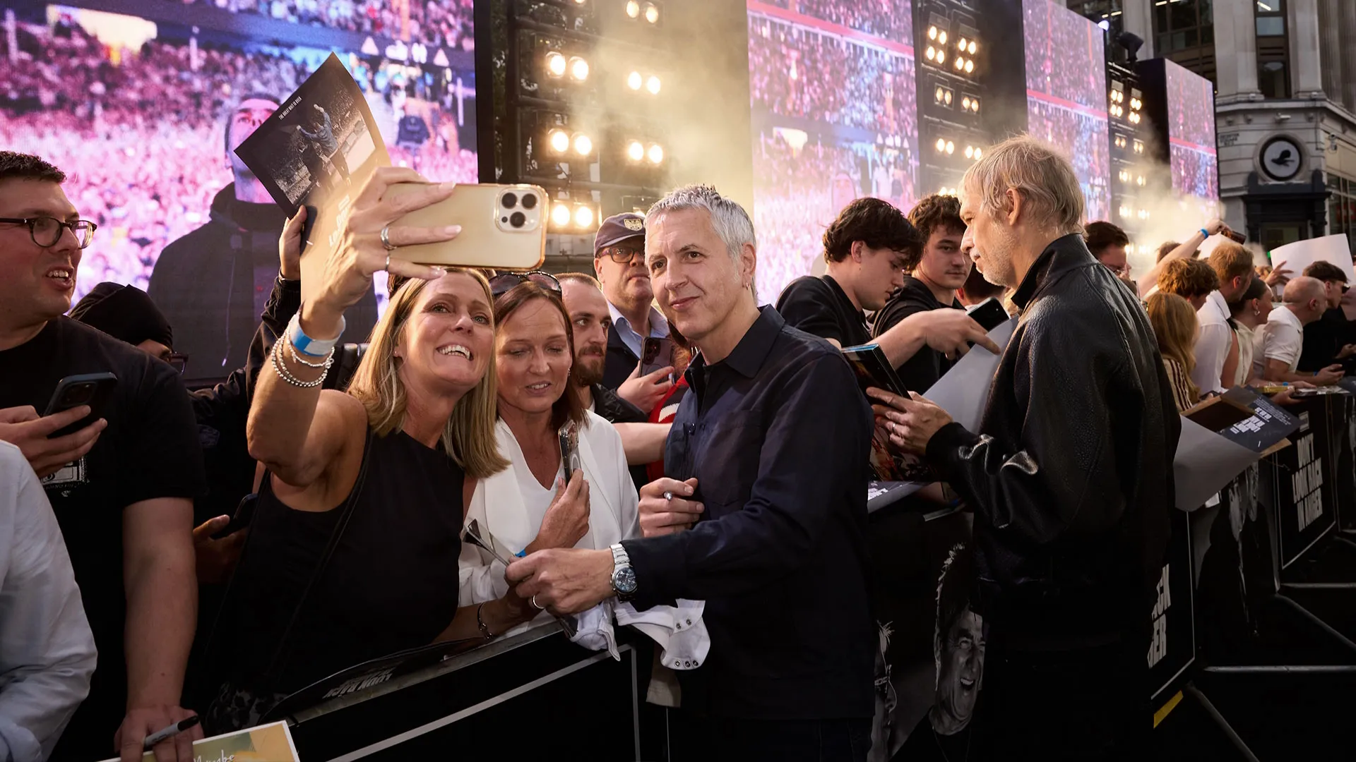Gem Archer takes a selfie with fans while Bonehead signs autographs at the London premiere of Oasis: Don’t Look Back in Anger.