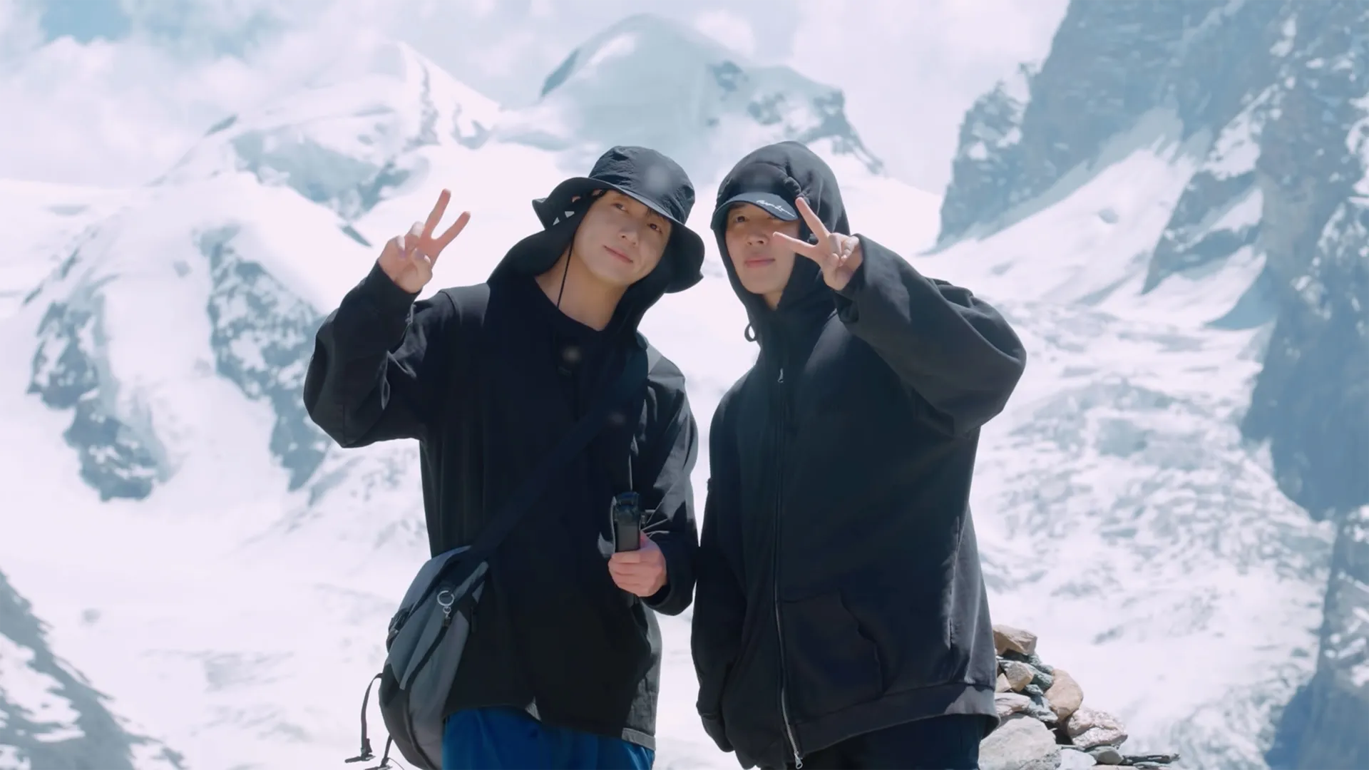 BTS's Jimin and Jung Kook posing together on a mountain top.