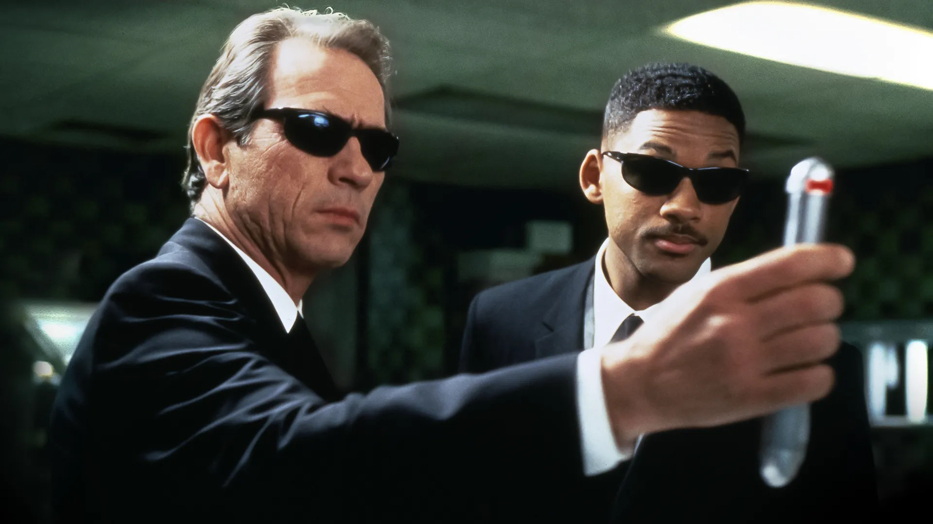 This image features Tommy Lee Jones and Will Smith in a scene from the 1997 sci-fi comedy Men in Black.