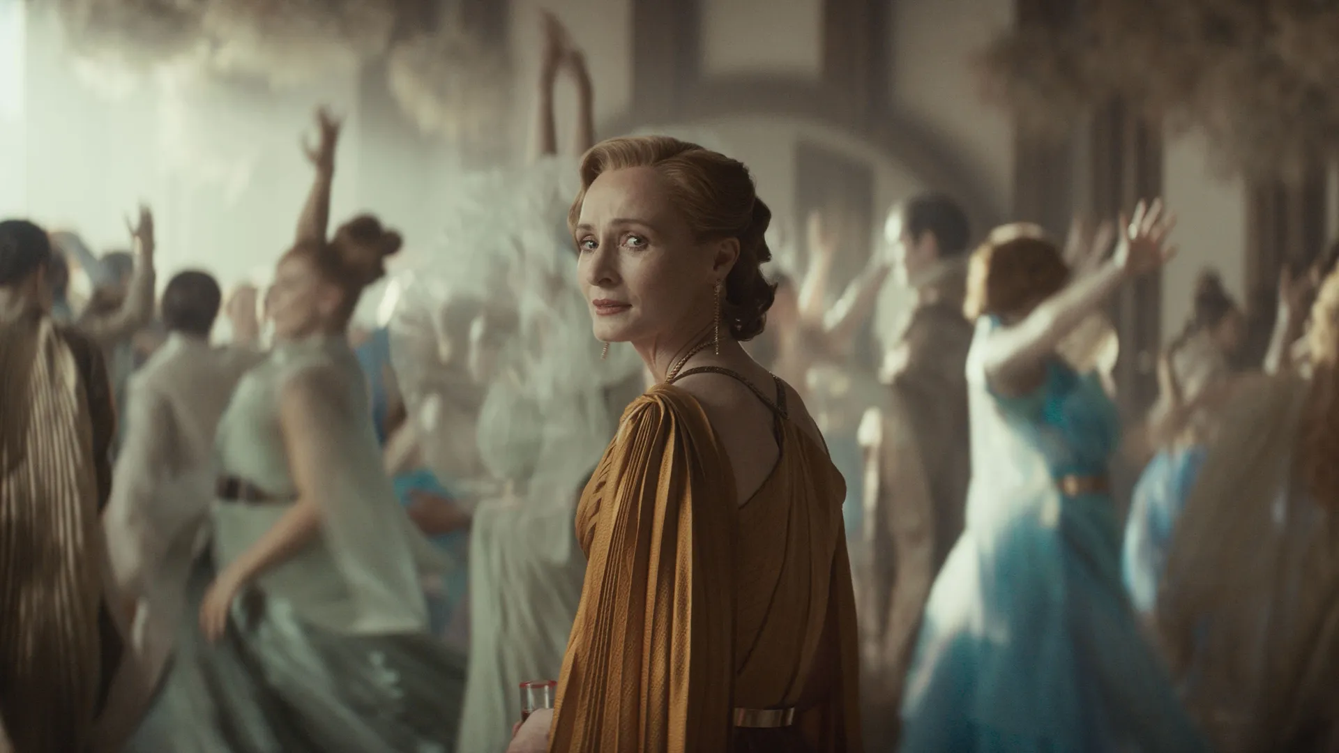 Mon Mothma (Genevive O'Reilly) looks back with an expression of anguish as wedding guests dance in the background.