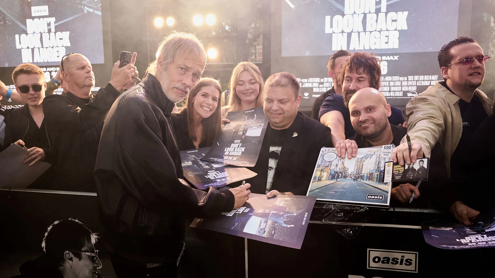 Andy Bell signs posters for fans at the London premiere of Oasis: Don’t Look Back in Anger.