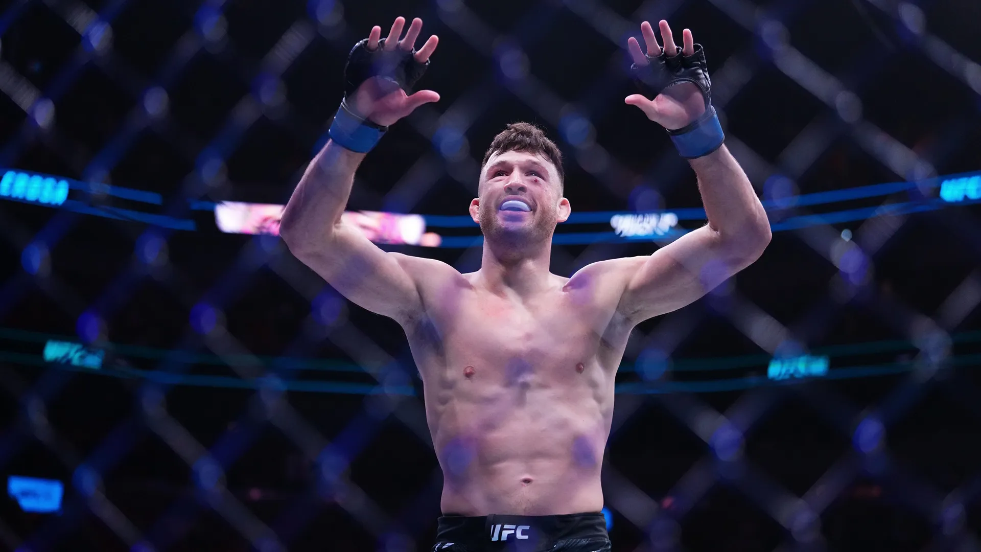 UFC fighter Julian Erosa celebrates a victory in the octagon.