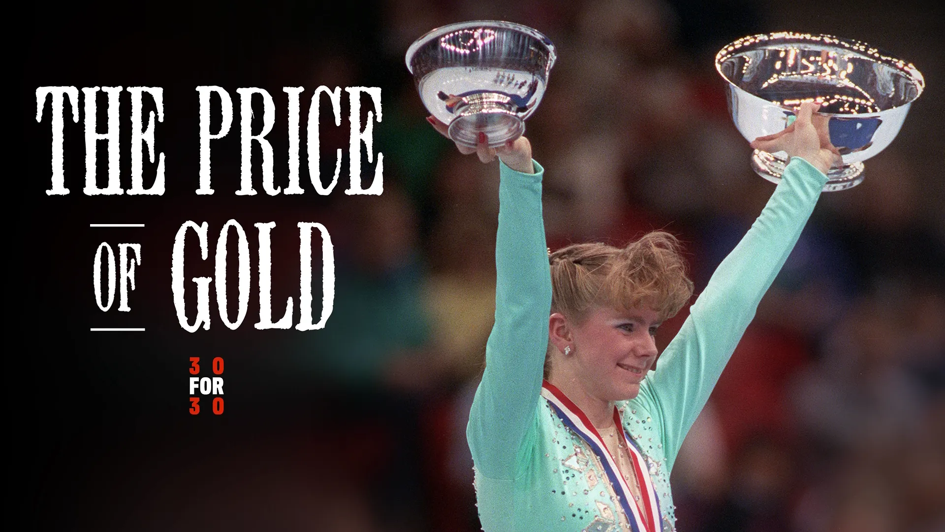 Tonya Harding proudly holds two trophies above her head