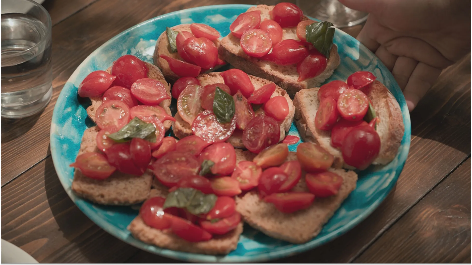 A plate of toasted bread with cherry tomatoes and basil