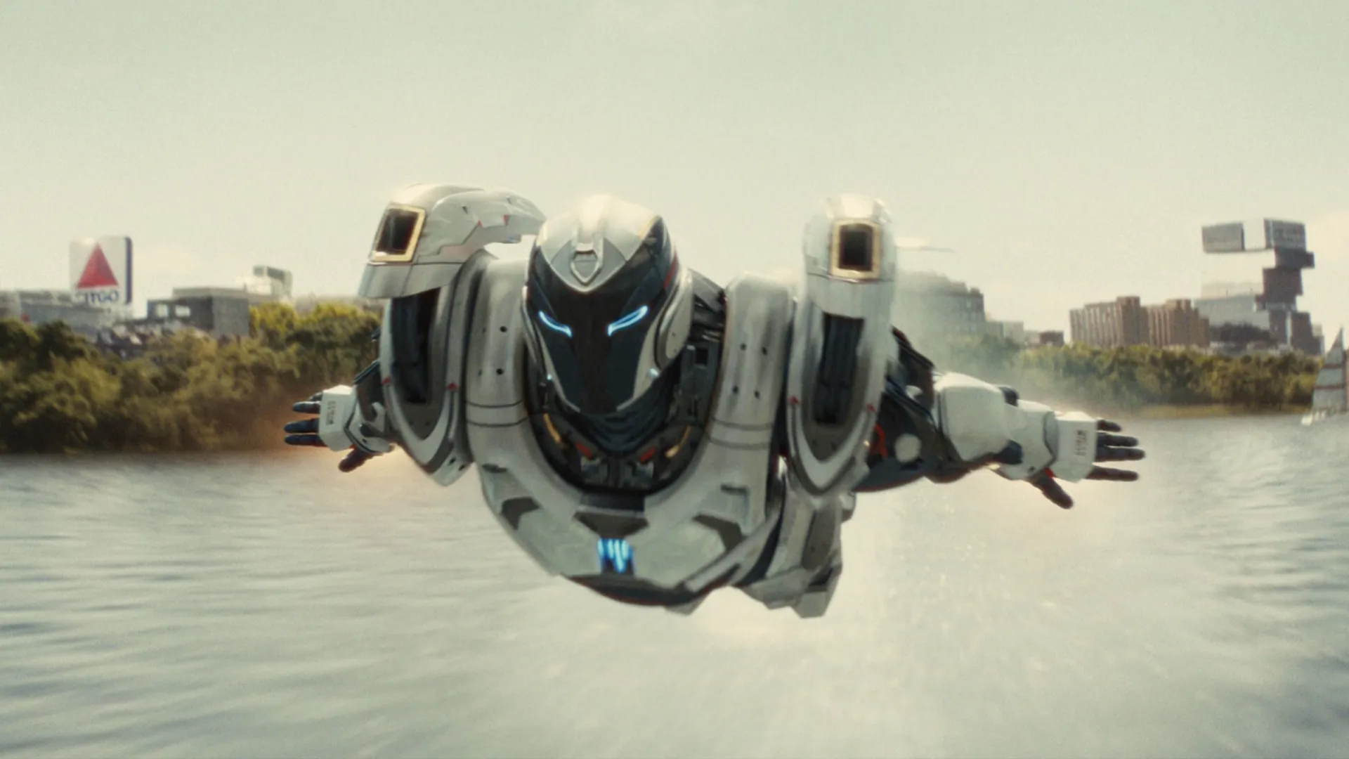 Ironheart in white armor flying across a body of water.
