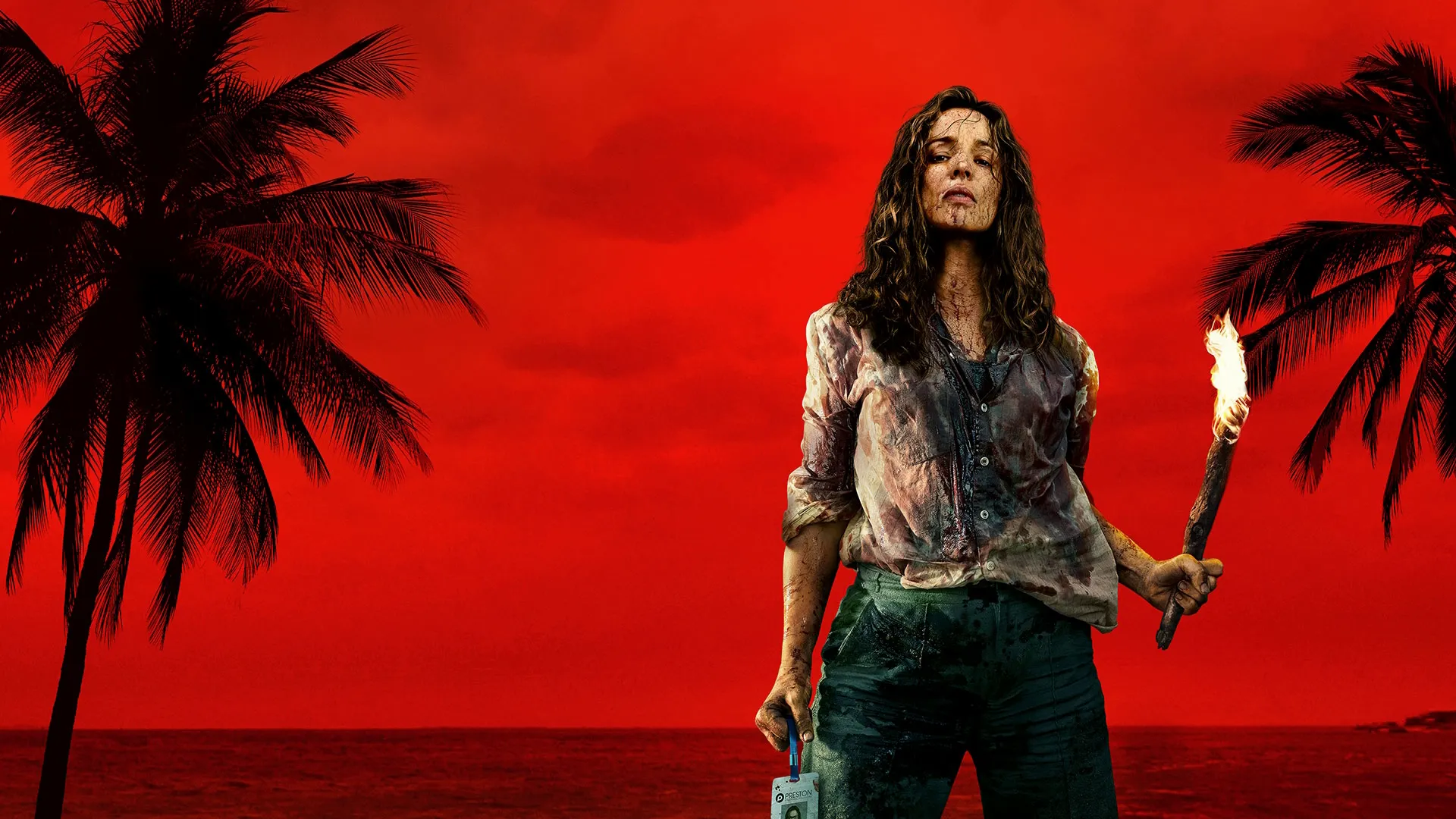 Key art for Send Help featuring a bloodied survivor holding a flaming torch on a tropical beach against a vivid red sky.