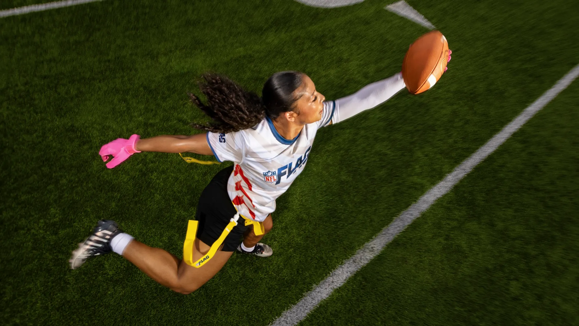 A young woman reaches out to grab the football.