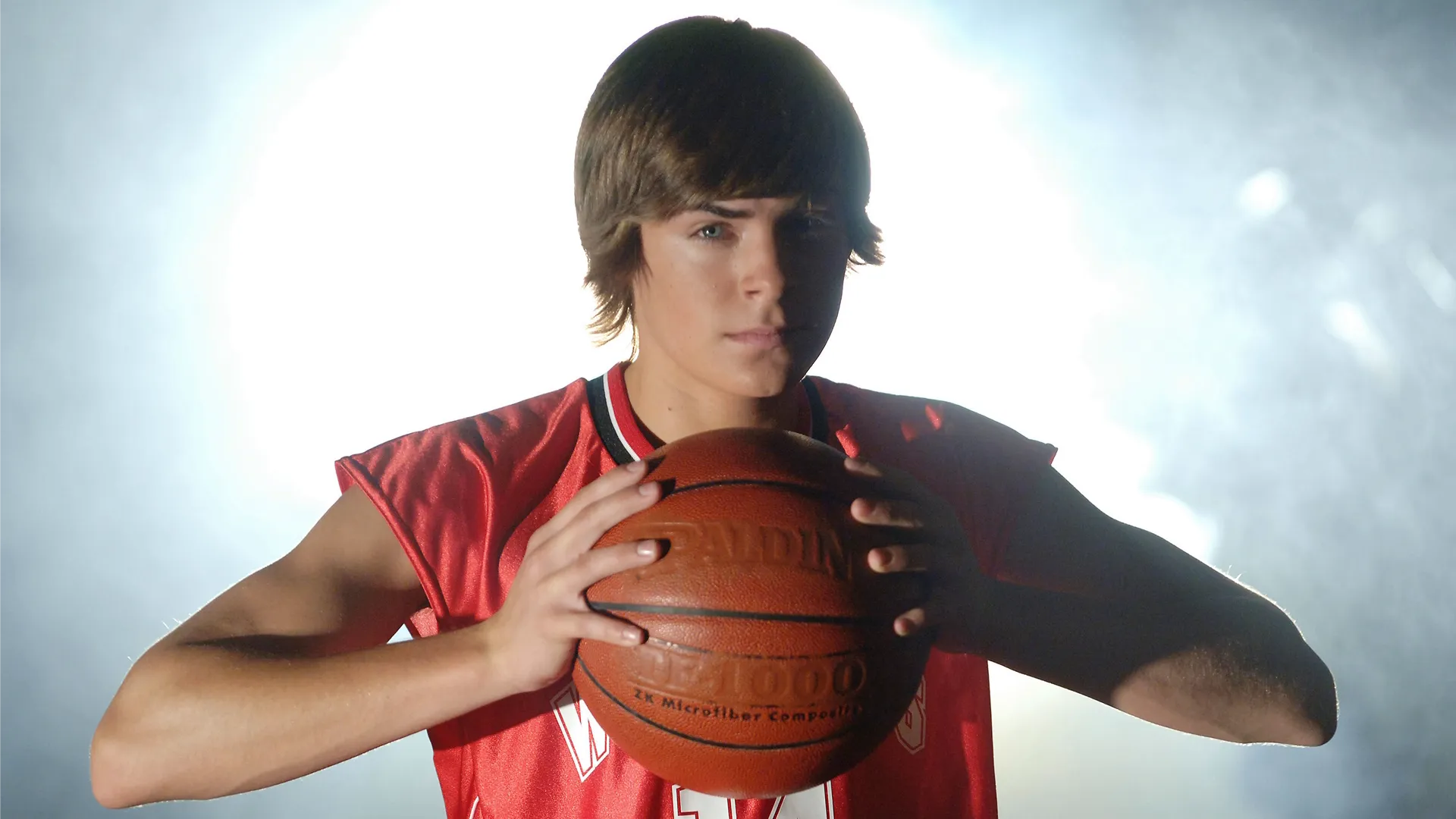 A closeup of Troy (Zac Efron) holding a basketball in High School Musical