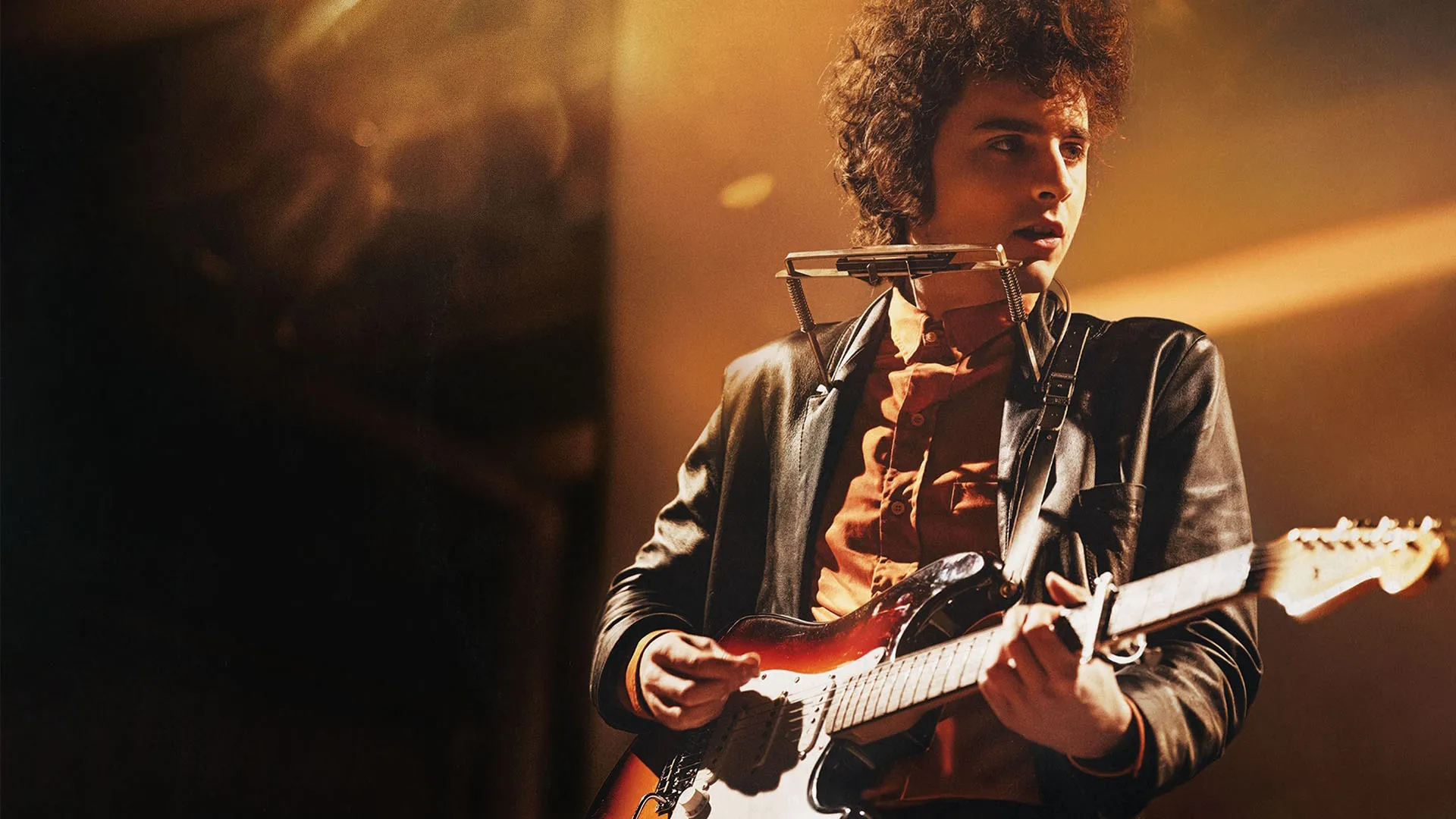 Timothée Chalamet as Bob Dylan in A Complete Unknown performs on-stage.