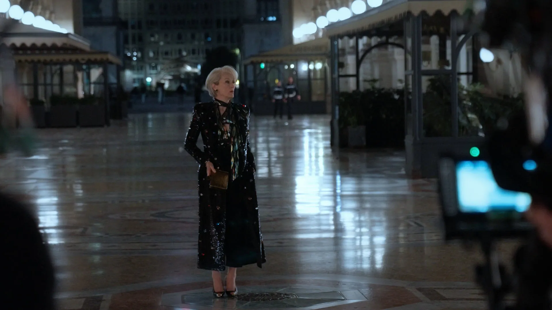 Miranda Priestly (Meryl Streep) standing outside at night in a black gown.