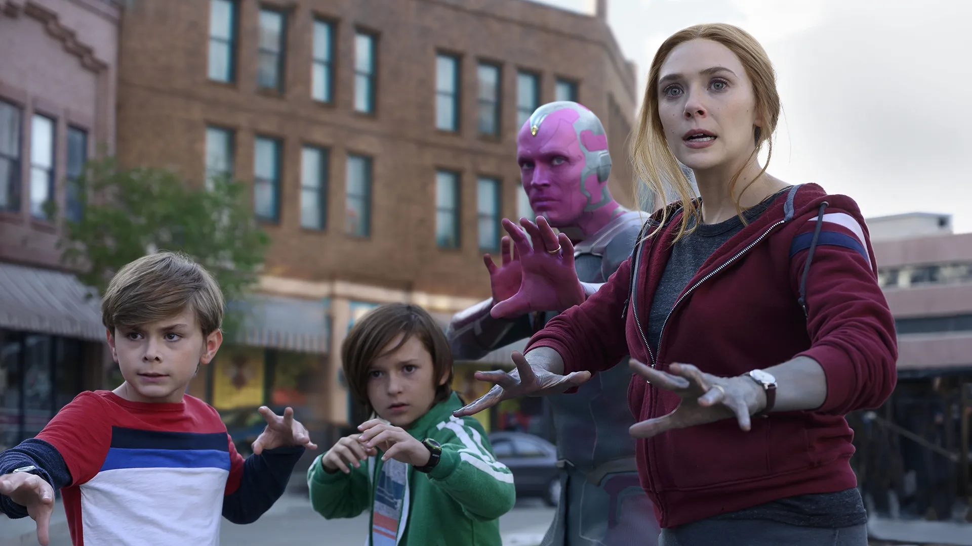 This image is a still from the Marvel Studios series WandaVision, featuring the characters Wanda Maximoff, Vision, and their sons, Billy and Tommy Maximoff. 