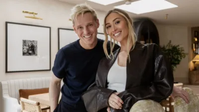 Jamie Laing and Sophie Habboo standing together in a living room.