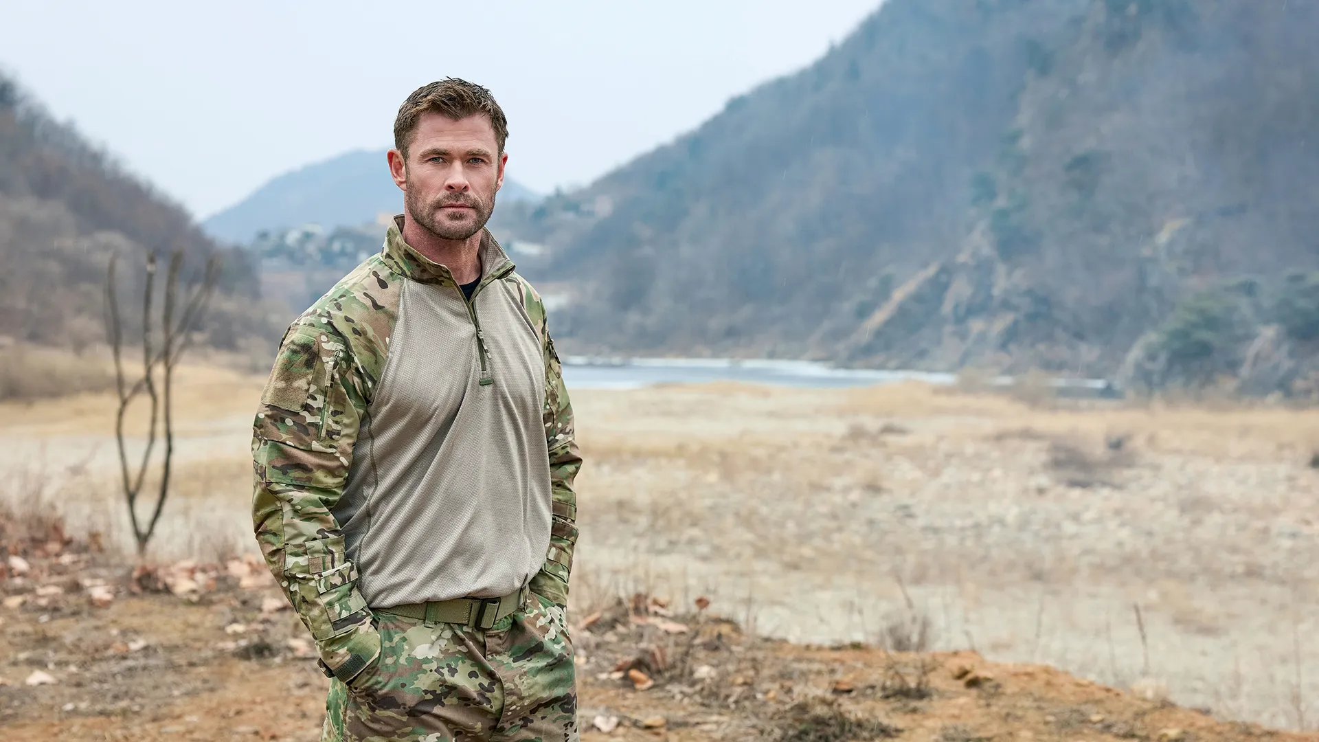 Chris Hemsworth standing in a clearing outdoors.