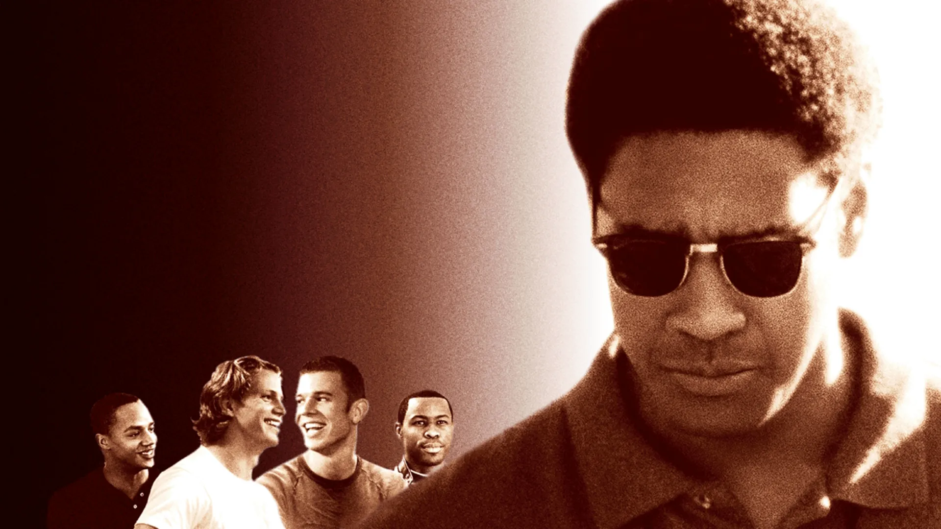 An image from Remember the Titans, featuring Denzel Washington in the foreground as Coach Herman Boone