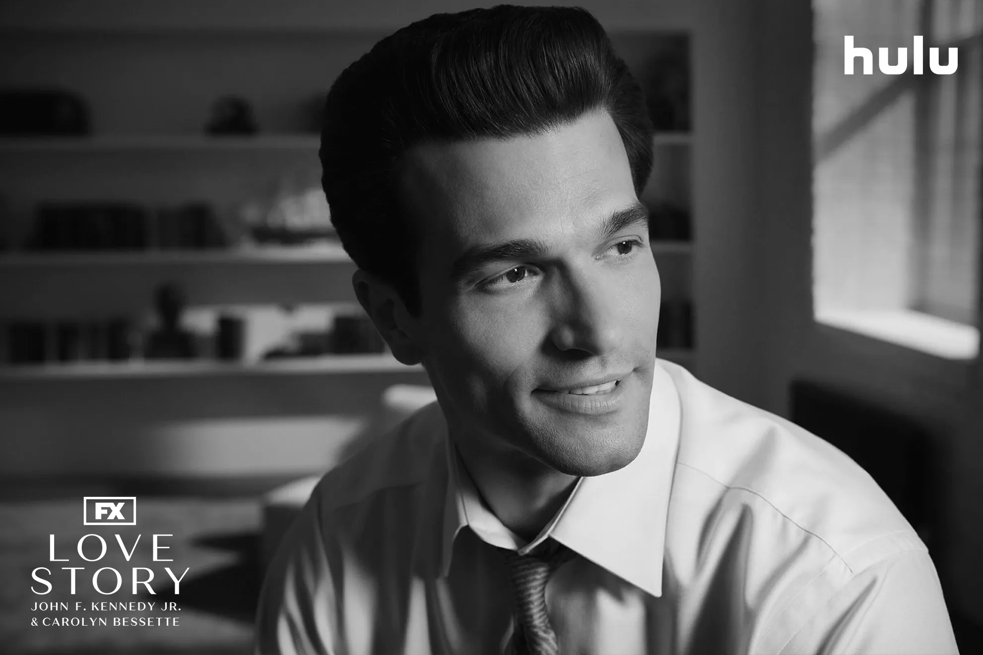 Close-up shot of John F. Kennedy Jr. (Paul Kelly) in a black and white set photo from FX's Love Story.