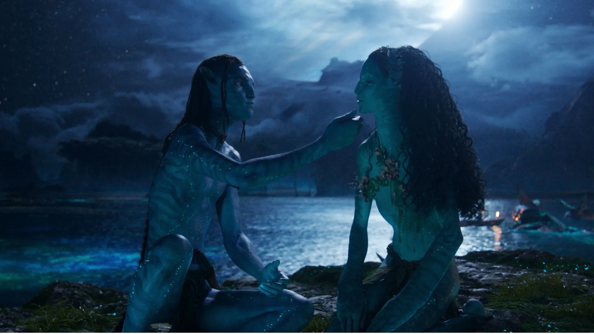 Lo'ak (Britain Dalton) touches Tsireya's (Bailey Bass) face by the ocean under the moonlight.