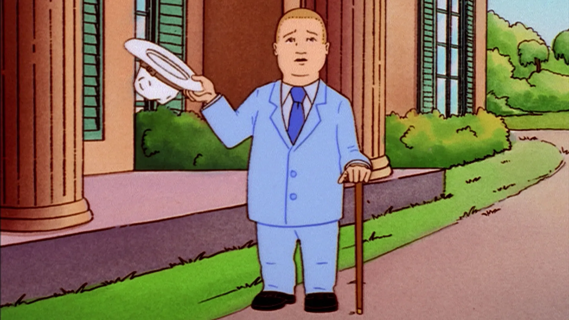 Bobby (Pamela Adlon), dressed in a pale-blue suit, lifts his white hat while holding a cane outside a mansion.
