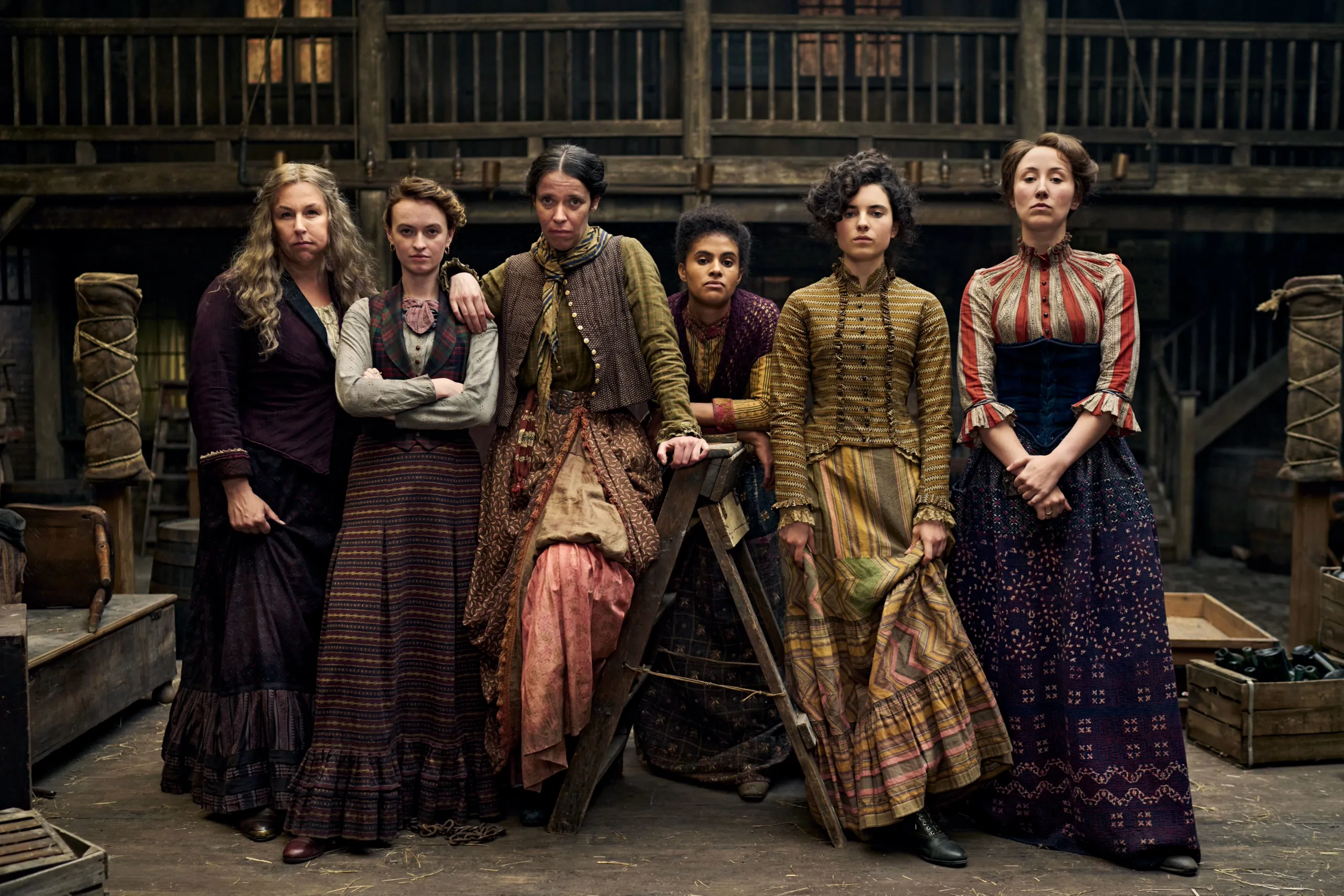 This image is a promotional photo for the Disney+ historical crime drama series A Thousand Blows. The actresses pictured are (from left to right) the female cast members who make up part of the gang known as the Forty Elephants: Hannah Walters as Eliza Moody, Erin Doherty as Mary Carr, the leader of the Forty Elephants gang, and Darci Shaw as Alice Diamond, Mary's loyal second
