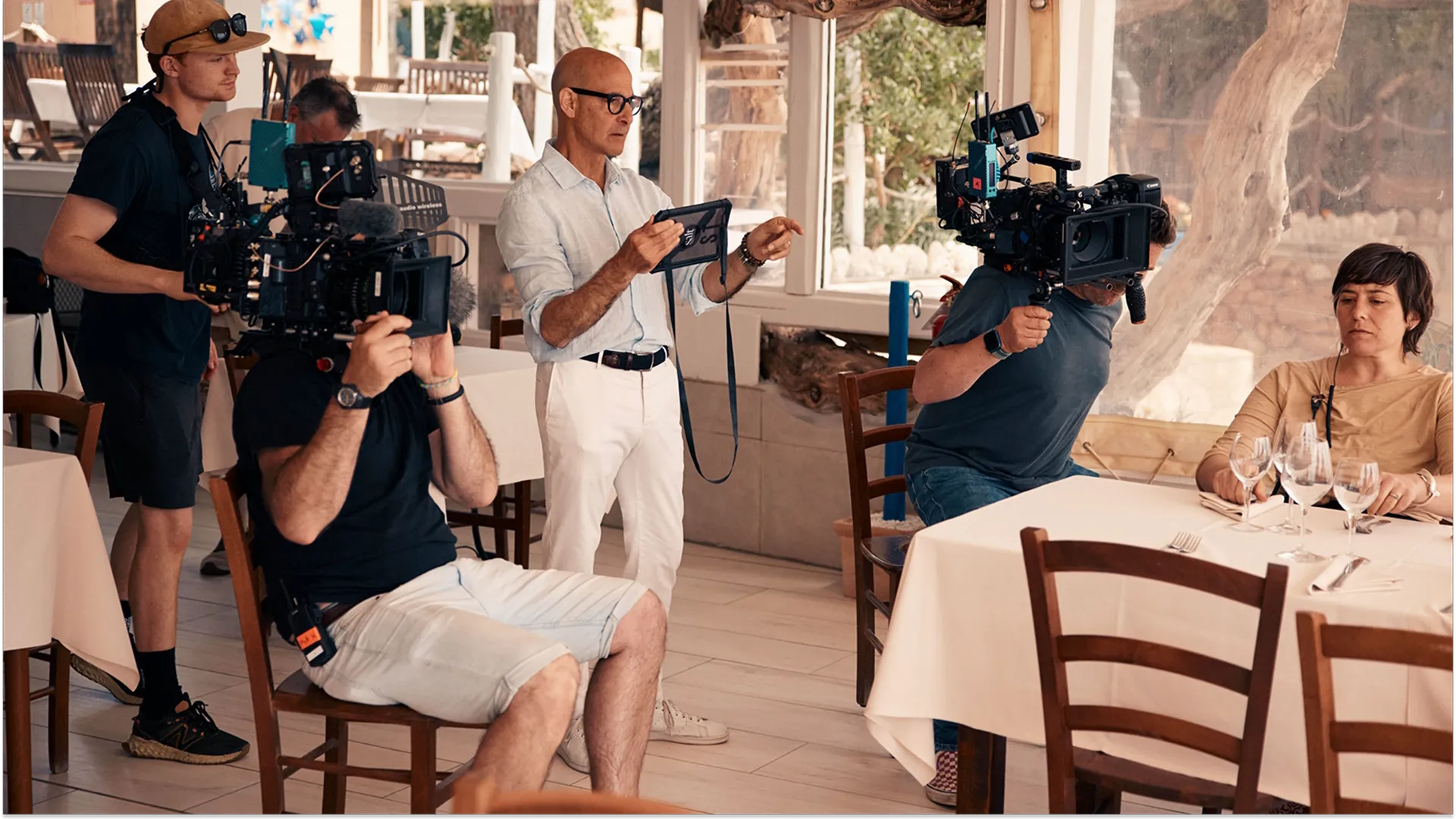 A behind-the-scenes photo of Stanley Tucci and the Tucci in Italy crew in a restaurant