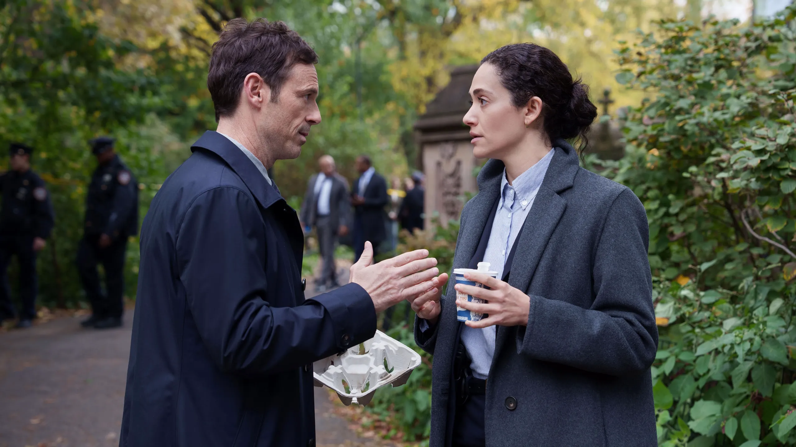 Danny and Alice talk near an outdoor investigation scene.