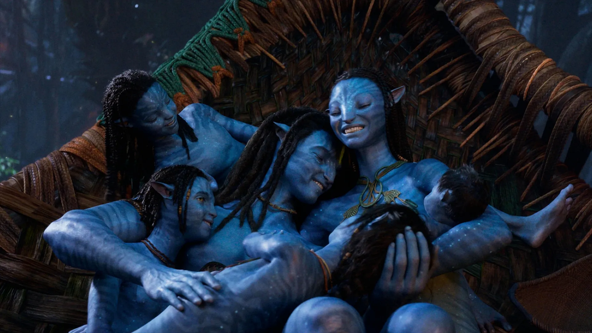 The scene depicts Jake Sully, Neytiri, and their children together in a quiet, intimate setting in a scene from Avatar: The Way of Water.