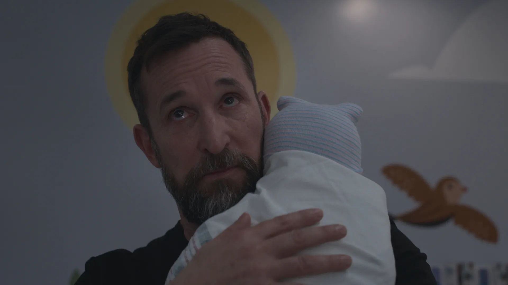 Dr. Robby (Noah Wyle) cradles a baby in The Pitt