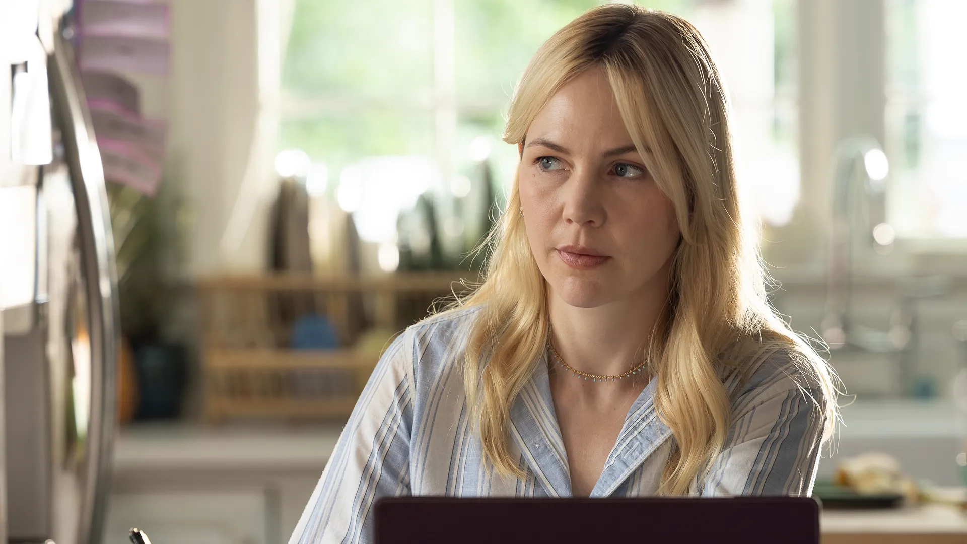 Catherine Delacroix (Adelaide Clemens) sitting in front of a laptop, looking at something off-screen