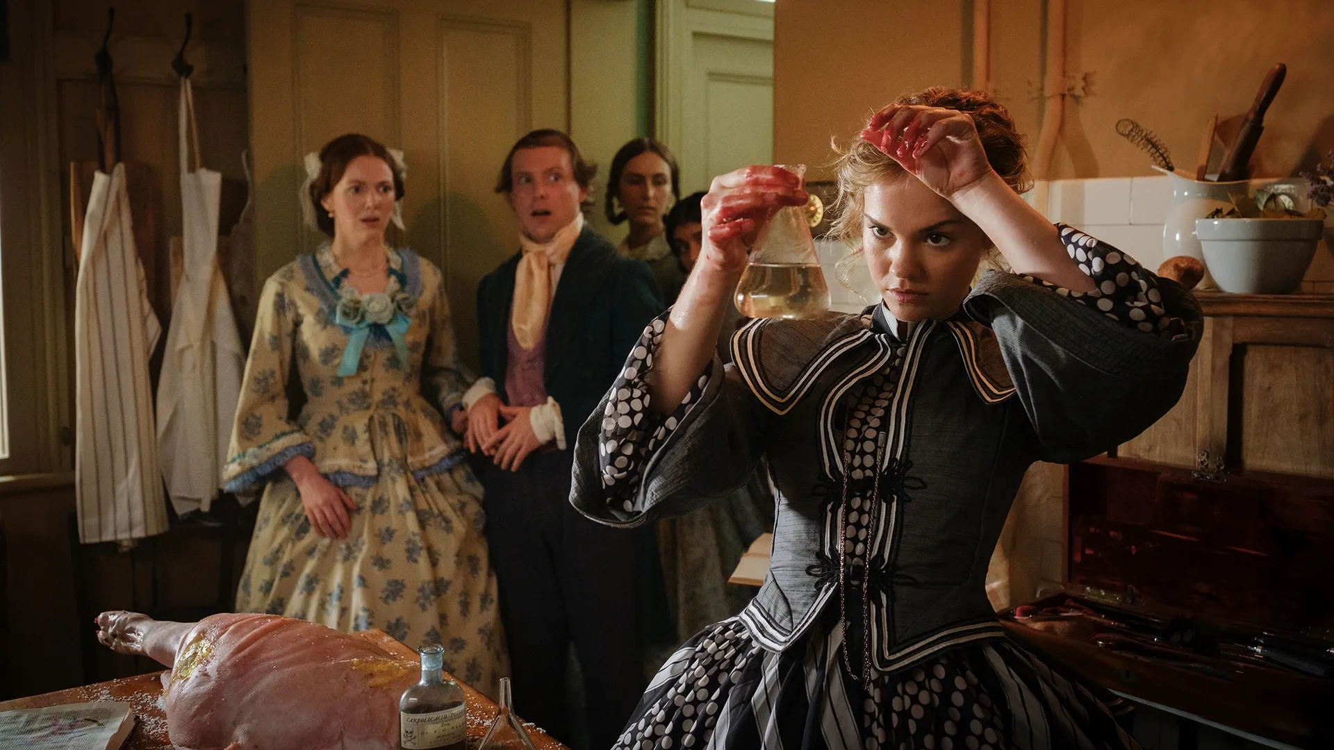 Lady Belle Fox (Maia Mitchell) performs an experiment with a dead pig while others look on aghast