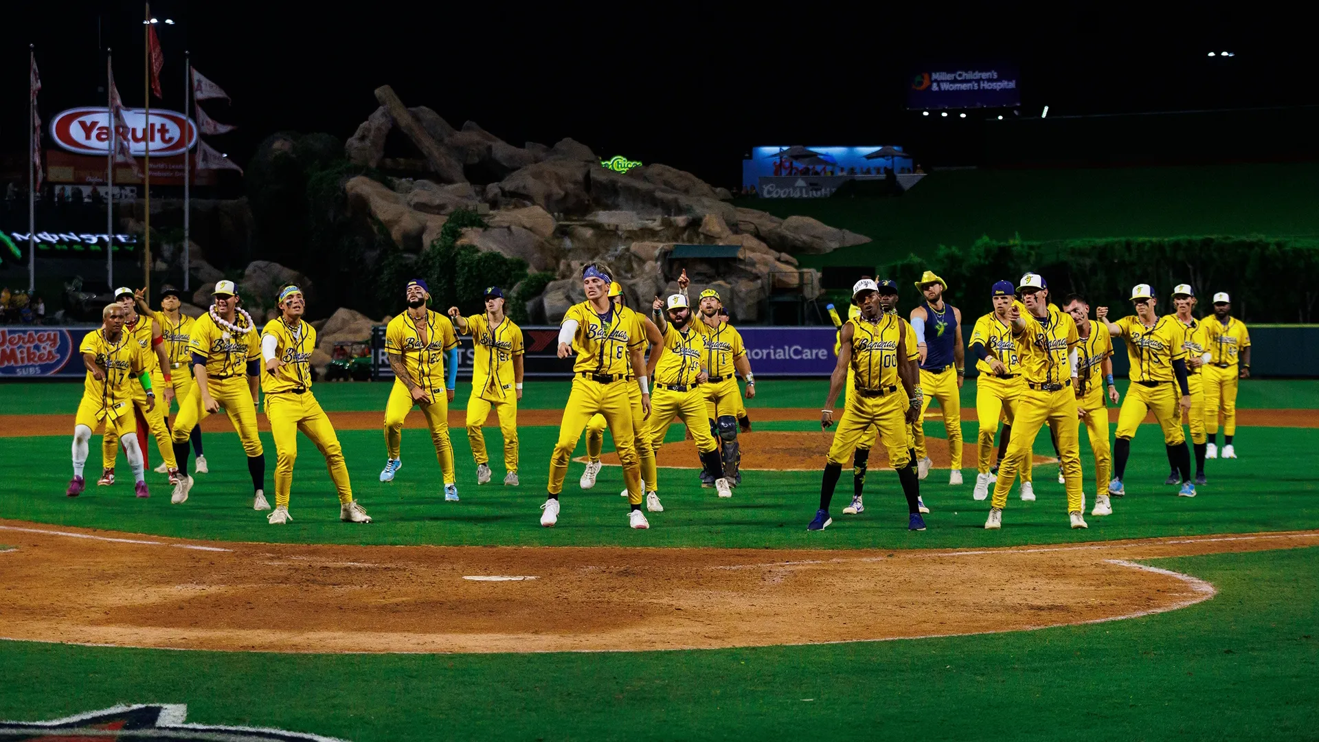 The Savannah Bananas team dancing on the baseball diamond.