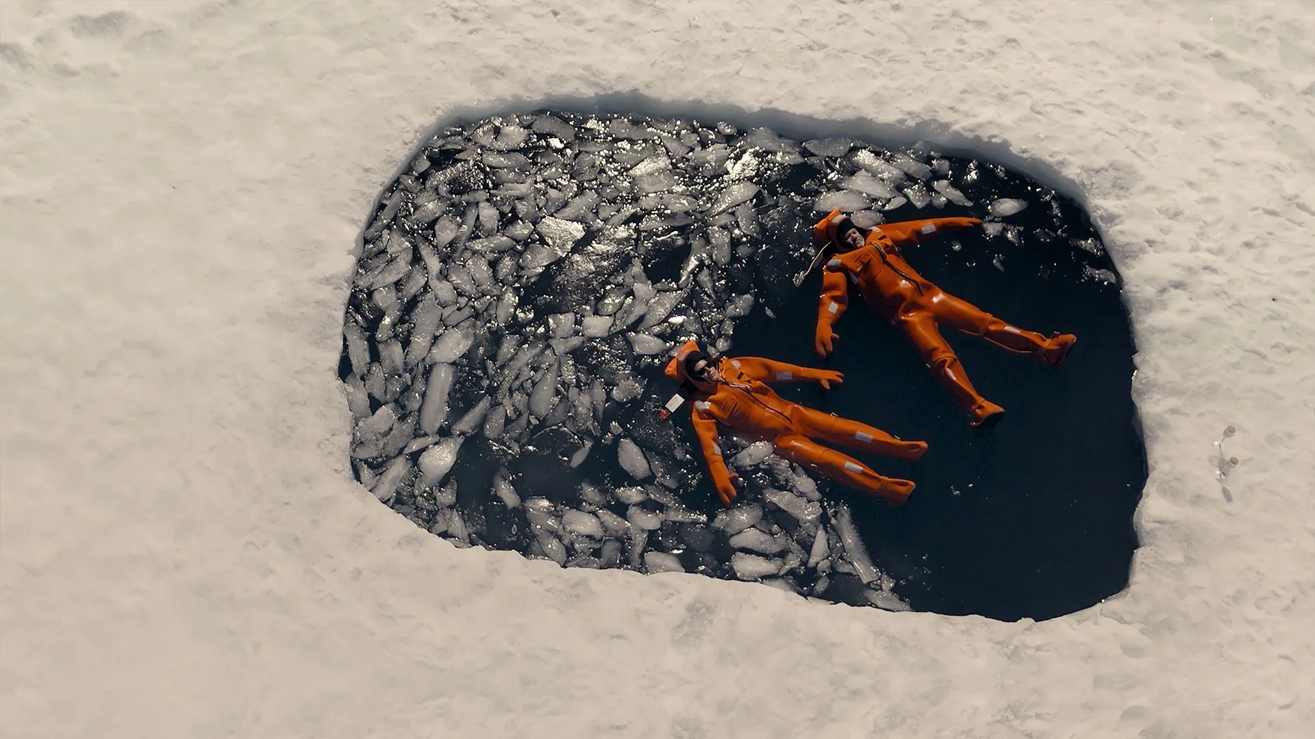 Wayne Rooney and Coleen Rooney float in icy water wearing orange immersion suits in The Real Rooneys.