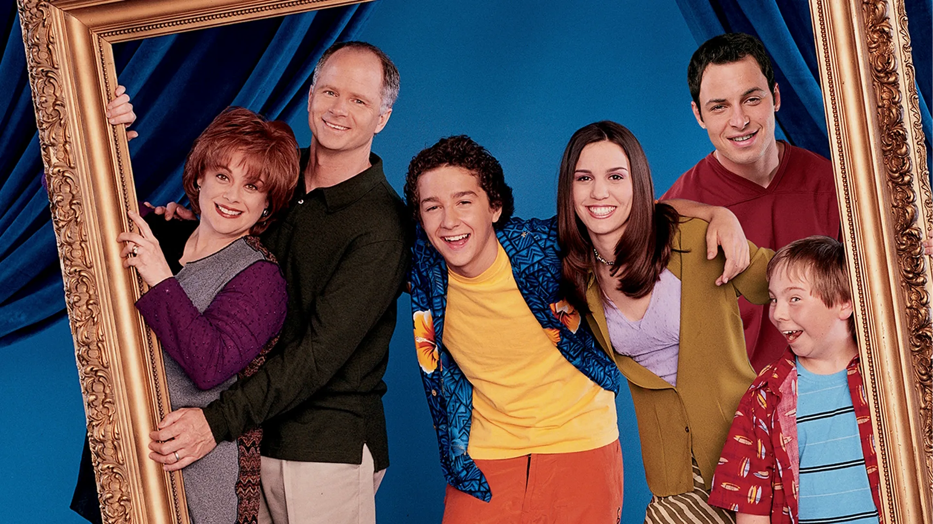 The cast of Even Stevens pose inside a giant prop picture frame