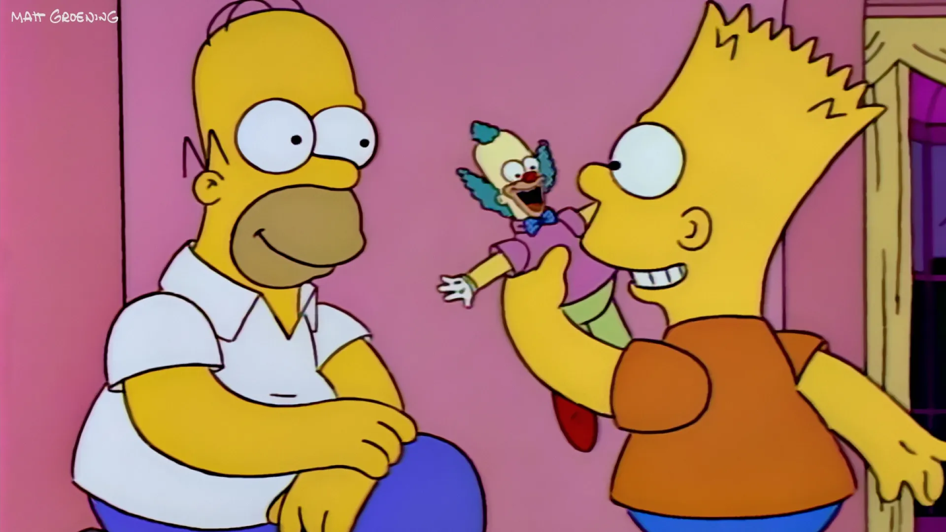 Bart Simpson enthusiastically shows a Krusty the Clown doll to a smiling Homer Simpson in a brightly colored living room.