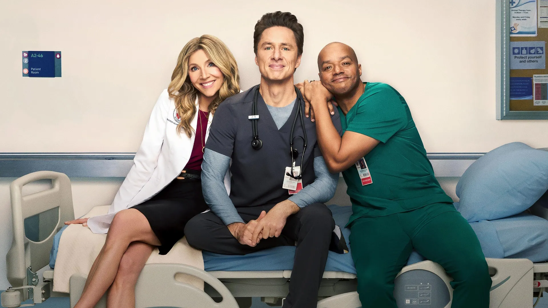 Elliot (Sarah Chalke), J.D. (Zach Braff), and Turk (Donald Faison) sit on a gurney, smiling
