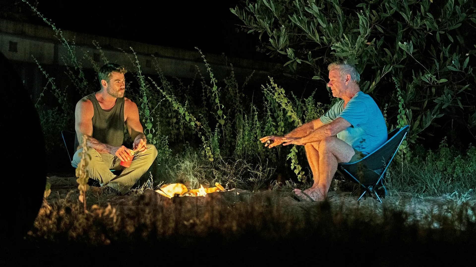 Chris and his father Craig sit by a fire in the Australian outback (Credit: National Geographic/Craig Parry)