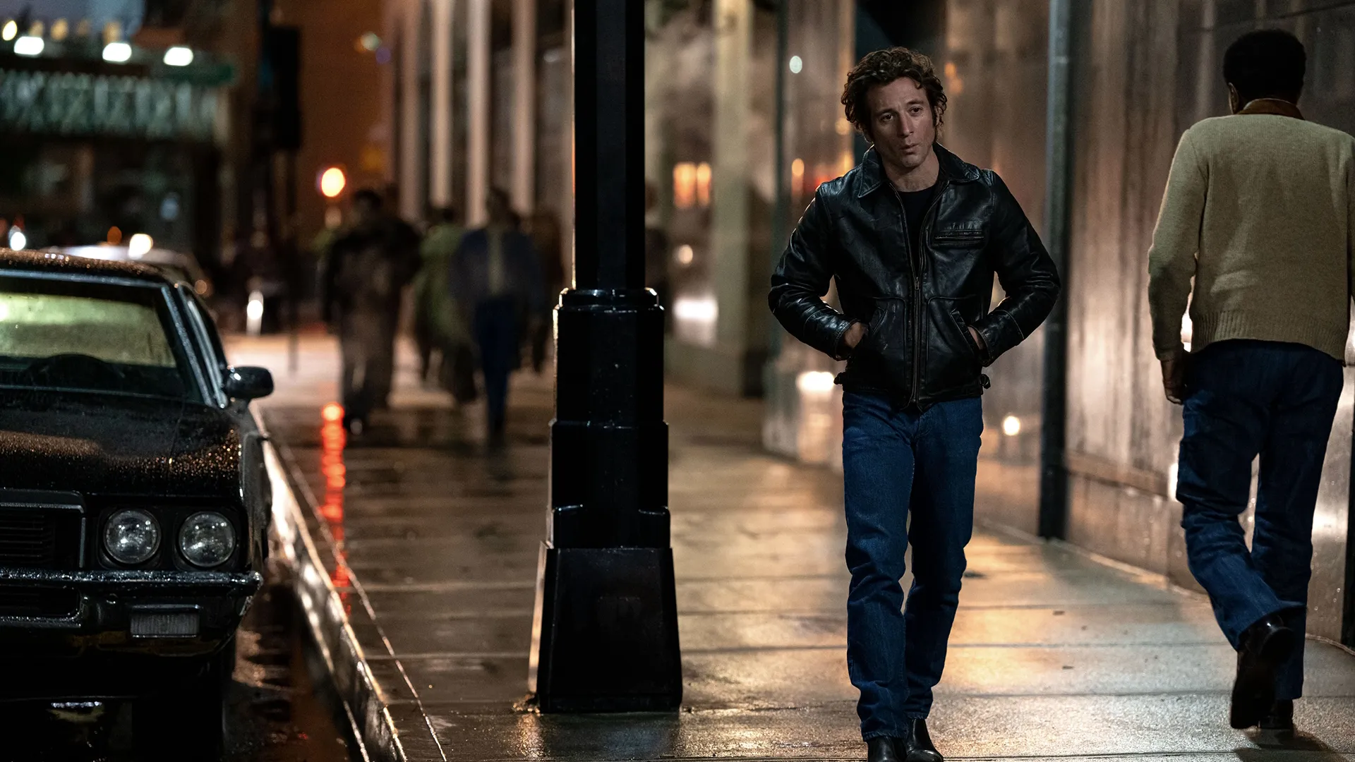 Bruce Springsteen (Jeremy Allen White) walks along a sidewalk at night.