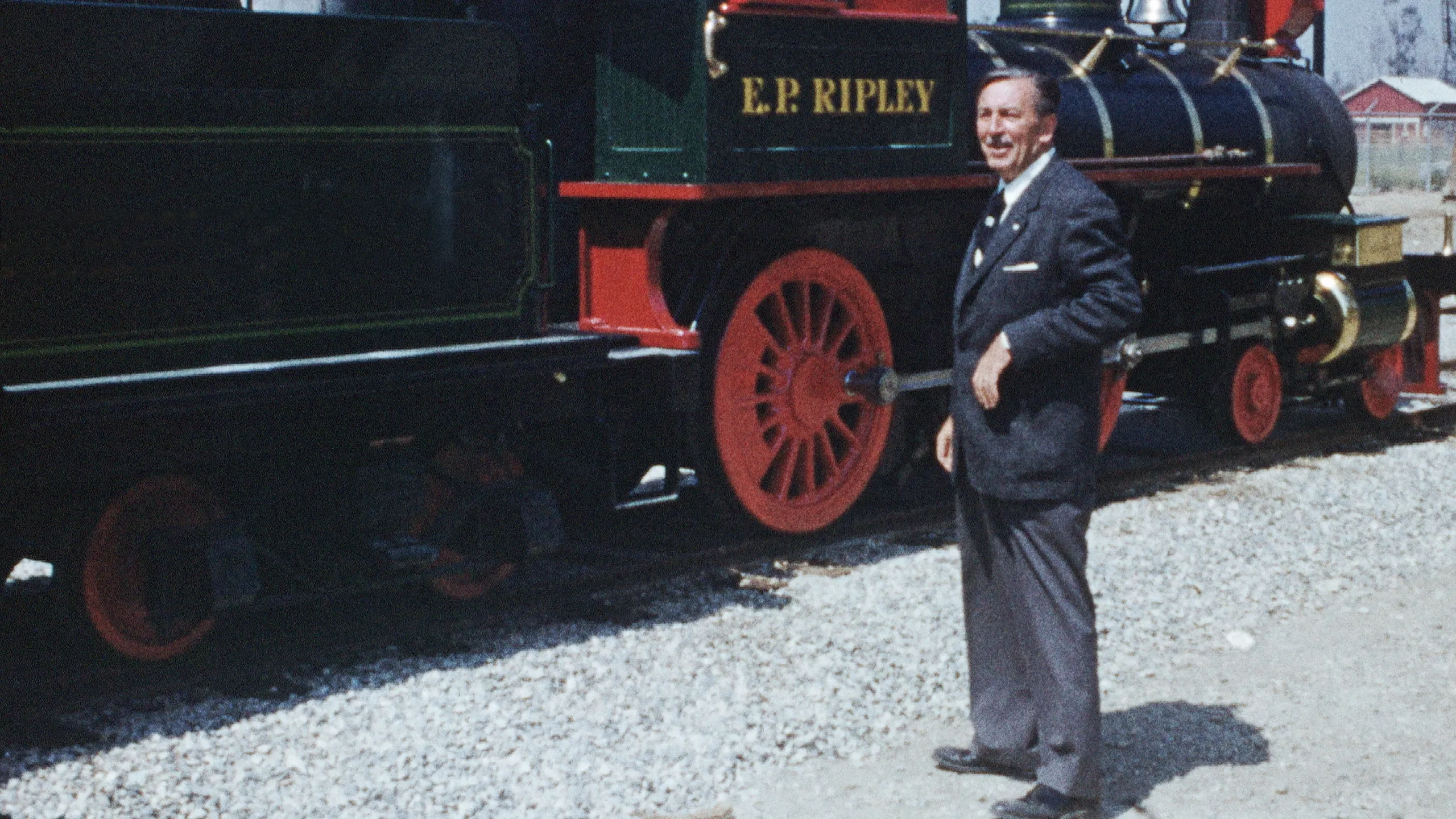 This image captures a moment with Walt Disney alongside the E.P. Ripley locomotive of the Disneyland Railroad. 