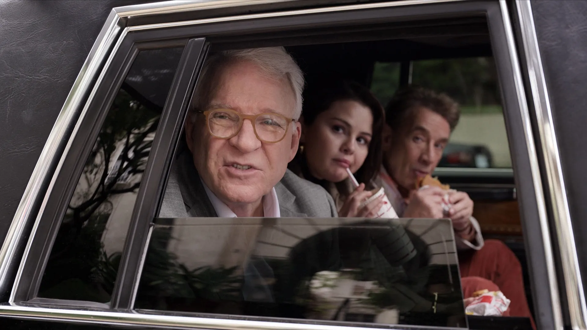 Charles-Haden Savage (Steve Martin), Mabel Mora (Selena Gomez), and Oliver Putnam (Martin Short) sit in the back of a car eating fast food together