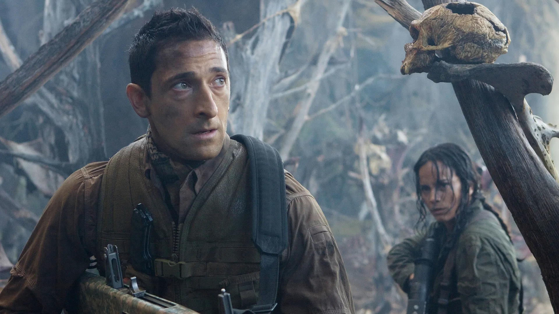 Royce (Adrien Brody) and Isabelle (Alice Braga) look cautiously around a misty forest