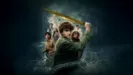 Percy Jackson (Walter Scobell) stands in the sea swinging a sword, with tentacles wrapping around him. Other characters from Percy Jackson and the Olympians appear in the background.