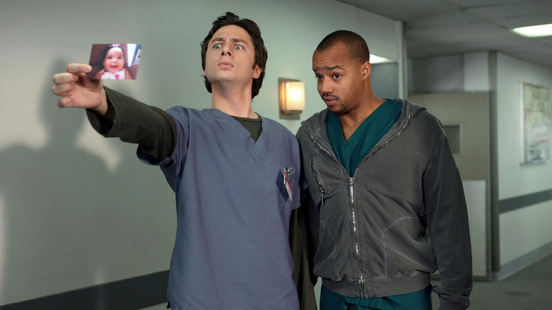 This image is a moment from the TV show Scrubs, featuring main characters J.D. (Zach Braff) and Turk (Donald Faison). 
