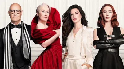 An official promotional image features the core cast of The Devil Wears Prada—Stanley Tucci, Meryl Streep, Anne Hathaway, and Emily Blunt—standing side-by-side in high-fashion black, red, and white outfits against a clean, paneled white background.