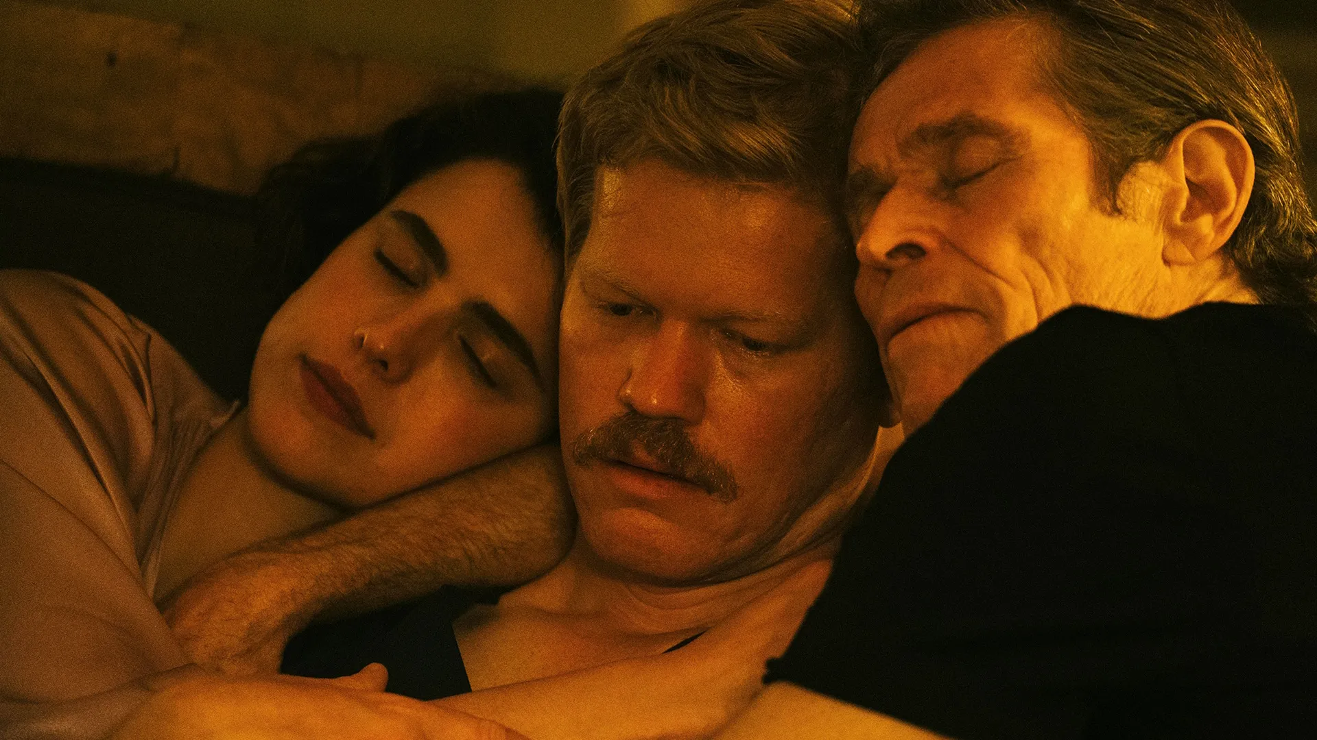 Characters played by Margaret Qualley, Jesse Plemons and Willem Dafoe snuggled together.