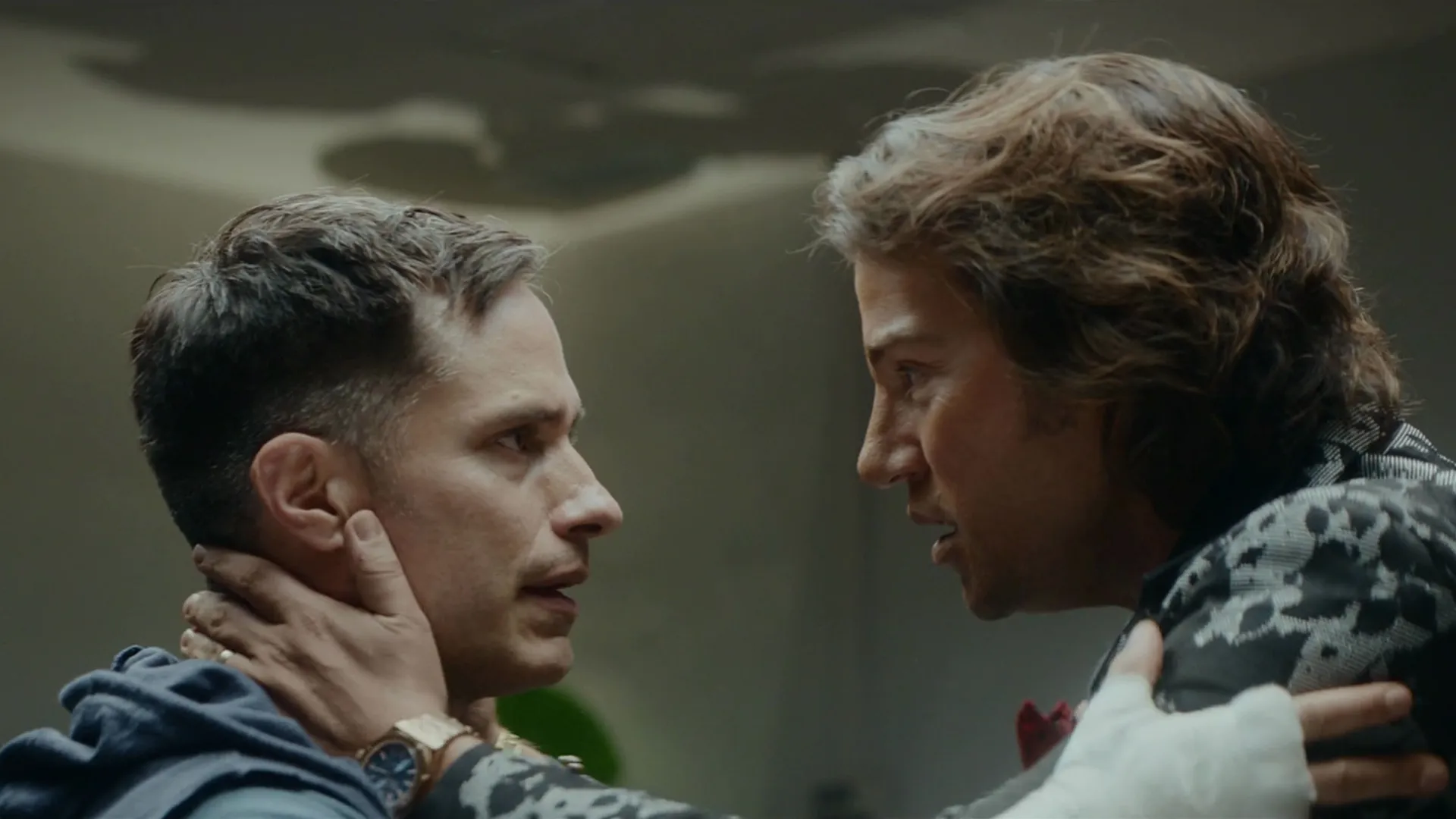 Andy Lujan (Diego Luna) and Esteban Osuna (Gael García Bernal) look into each other's eyes with their hands on each other's shoulders.