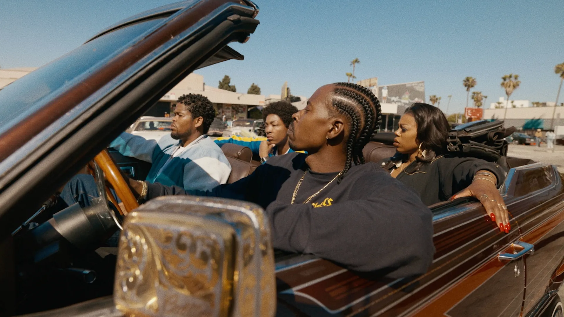 This image shows a promotional still from the upcoming FX spin-off series The Drop: A Snowfall Saga, featuring characters Leon Simmons (played by Isaiah John) and Wanda Bell (played by Gail Bean) riding in a classic convertible in 1990s Los Angeles.