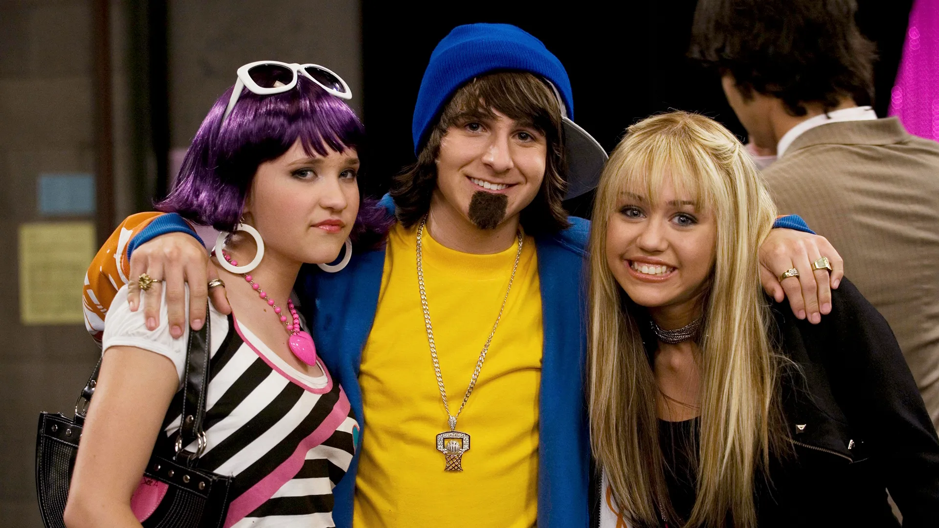 This image shows a moment in time featuring characters from the television series Hannah Montana. The photo features characters Miley Stewart, Lilly Truscott, and Oliver Oken. 
