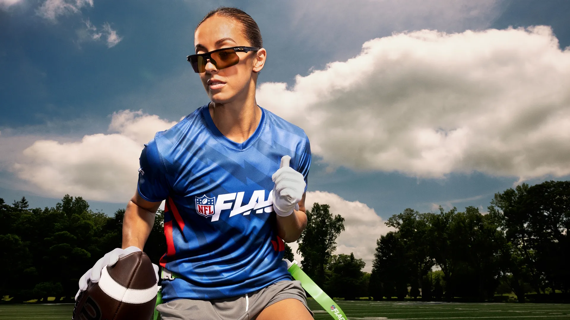 Close-up of a young woman running with the football in her right hand.