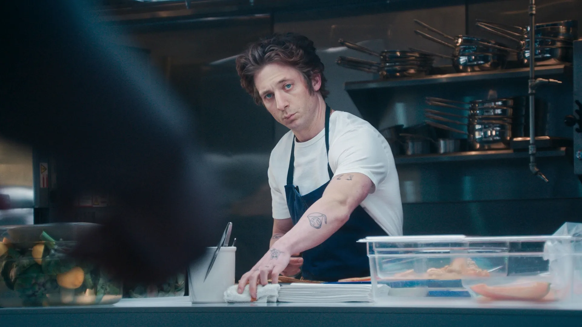 Carmy (Jeremy Allen White) preparing food in the restaurant kitchen.