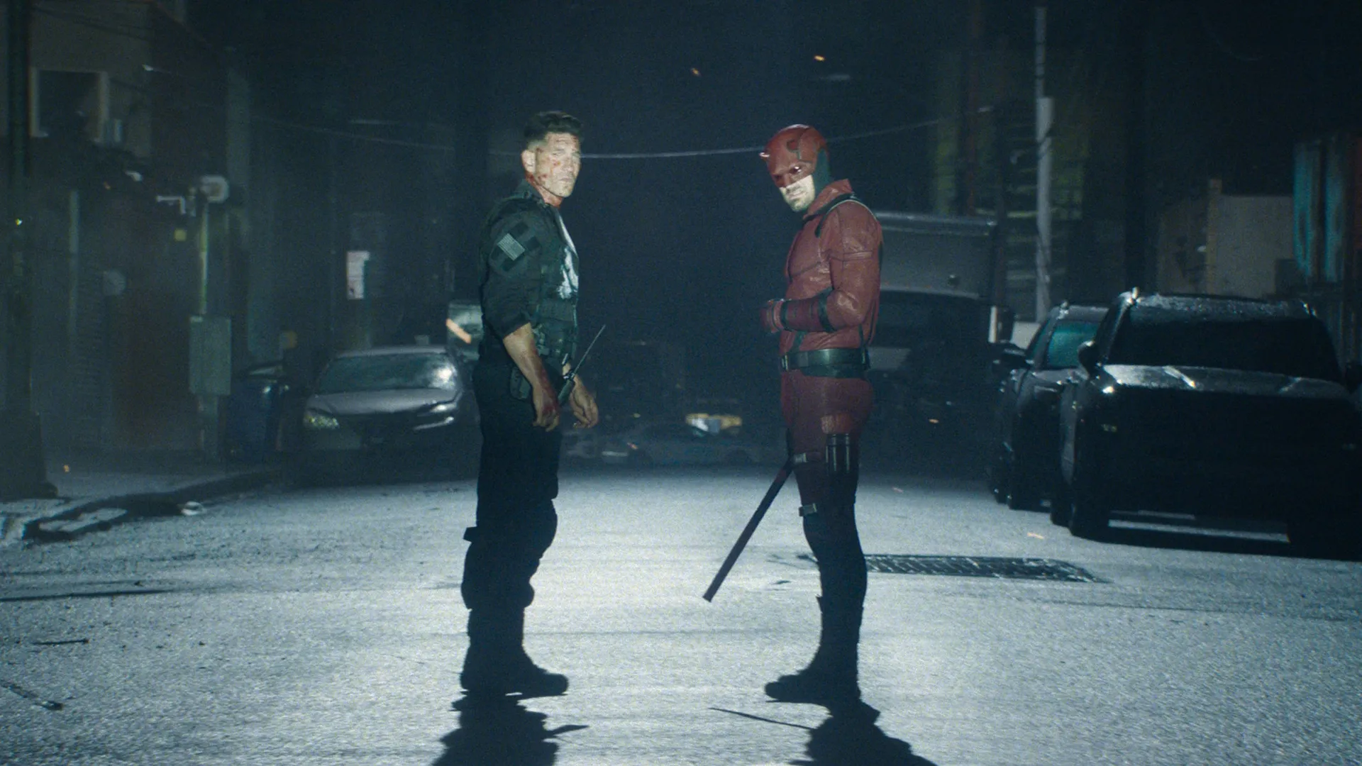 The Punisher (Jon Bernthal) and Daredevil (Charlie Cox) standing together in the middle of a road at night.